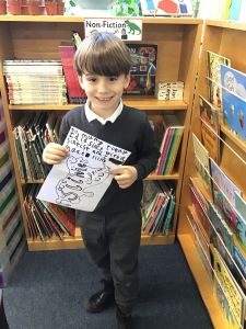 Small child (dark hair and dark eyes smiling and wearing a navy uniform) is smiling holding a picture of slime with the words 'To mummy today I did science with a scientist and I made slime'.